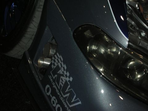 1998 Ford Crown Victoria - close-up of a metallic-gray car's headlight and front fender carrying a KW Suspensions decal and circular vents.