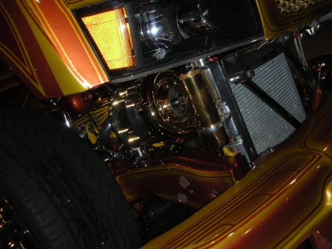1998 Ford Crown Victoria - close detail of gold-plated, engraved chrome engine and chassis parts on a candy-painted custom car with pinstriping.