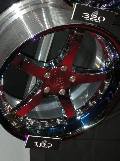 1998 Ford Crown Victoria - polished multi-spoke custom wheel with red accents sits on a black display labeled 320 Satsuma and 103.