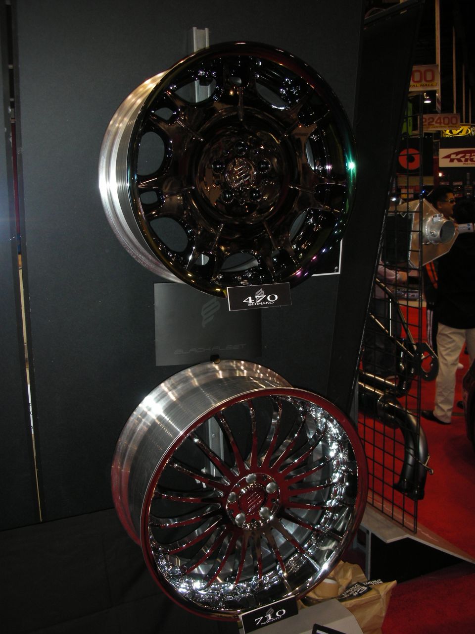 Two custom wheels on display, a black mesh and a chrome multi-spoke