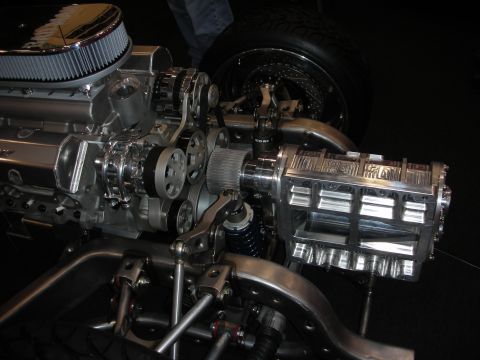 1998 Ford Crown Victoria - highly polished blown V8 engine with a roots supercharger sits in a custom tube chassis, with chrome suspension visible.