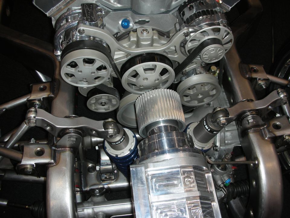 Front of a polished engine showing serpentine pulleys and supercharger