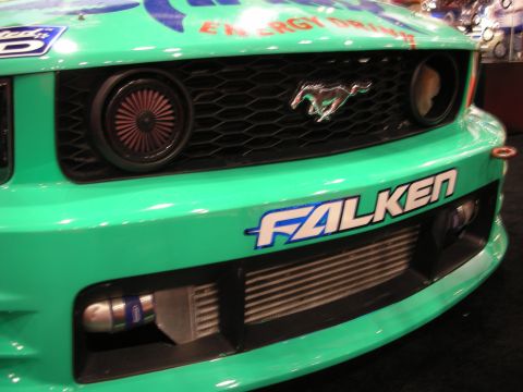 1998 Ford Crown Victoria - Close-up of a teal Mustang's front fascia showing the Ford pony grille emblem, an intercooler, and a Falken decal.