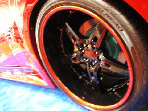 1998 Ford Crown Victoria - Tight close-up of a chrome-and-black multi-spoke wheel with a red lip on a Pirelli P Zero Nero tire.