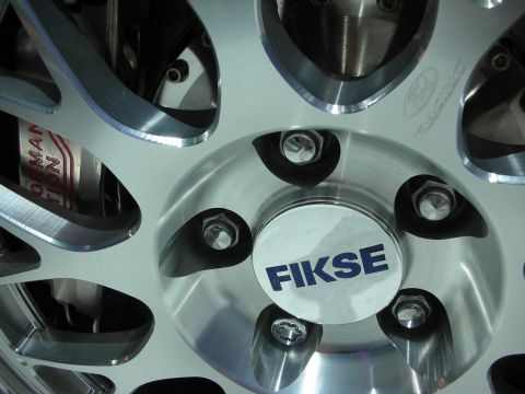 1998 Ford Crown Victoria - Close-up of a polished multi-spoke Fikse wheel showing the center cap with blue FIKSE lettering and a red brake caliper behind.