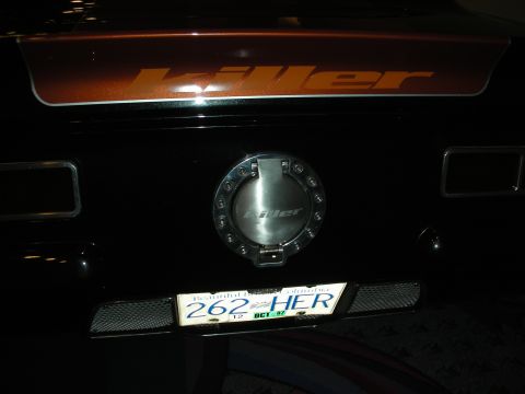 1998 Ford Crown Victoria - Rear of a dark custom vehicle with orange Killer lettering, a billet fuel filler door and a license plate reading 262 HER.