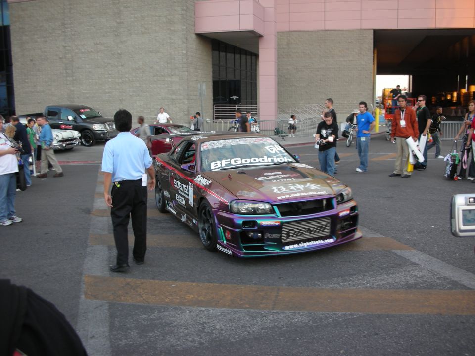 Purple drift-style coupe with BFGoodrich livery and crowd outside a venue
