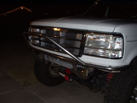 1993 Ford Bronco - Close-up of a white Ford F-Series truck's front end, a custom bumper and grille.