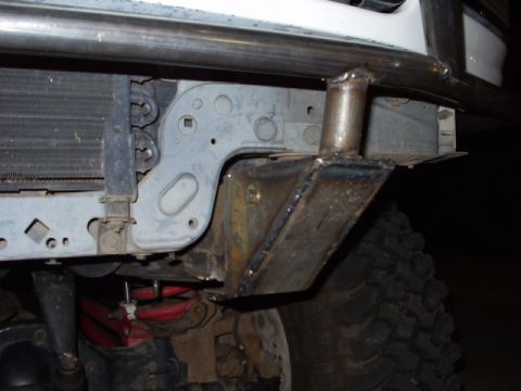 1993 Ford Bronco - Custom prerunner bumper bracket welded to the frame of a 1993 Ford Bronco, partially covering the radiator and tire.