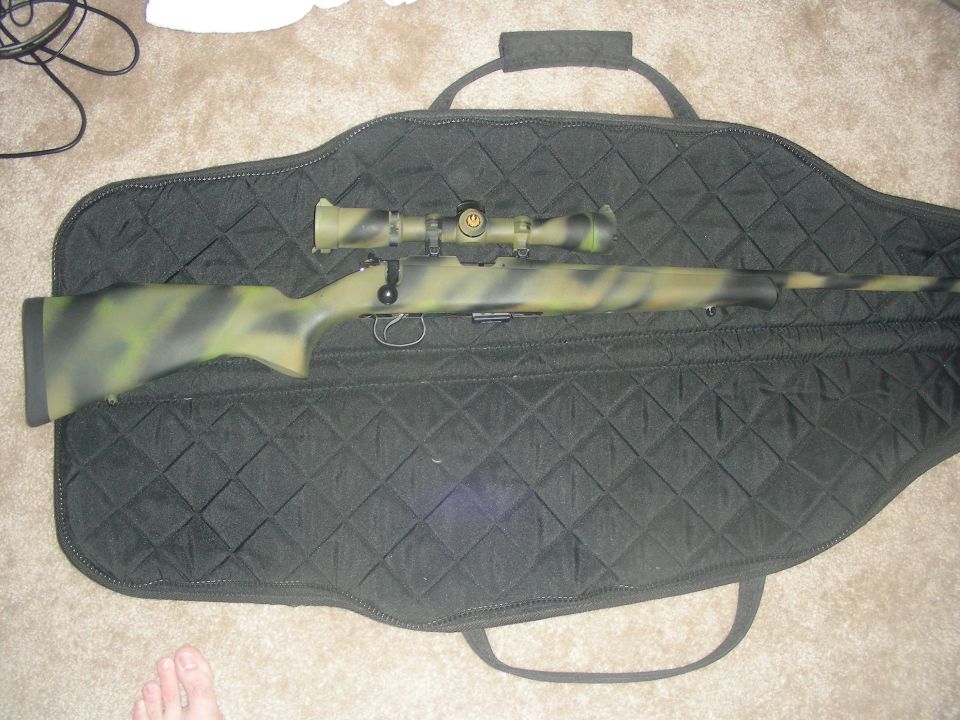 Camouflage rifle with scope in a black gun bag