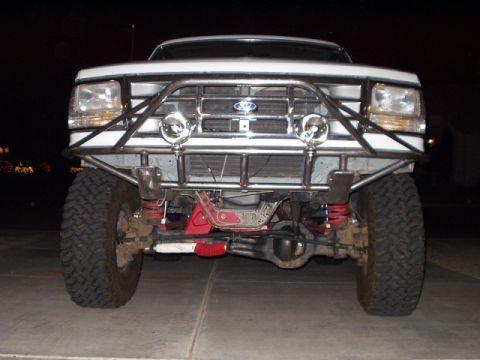 1993 Ford Bronco - Front view of a white 1993 Ford Bronco a custom prerunner bumper with integrated off-road lights.