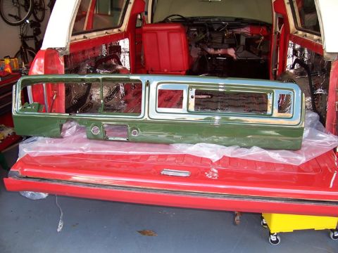 1978 Ford Bronco - A green and chrome grille assembly is laid out on a red tailgate, likely for restoration.