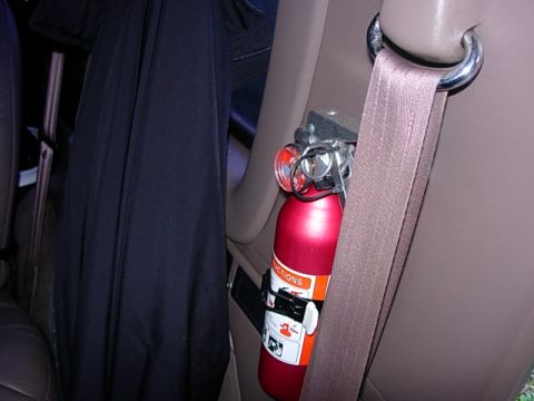 1993 Ford Bronco - Interior view of a vehicle shows a mounted fire extinguisher and a seatbelt attached to the car's frame.