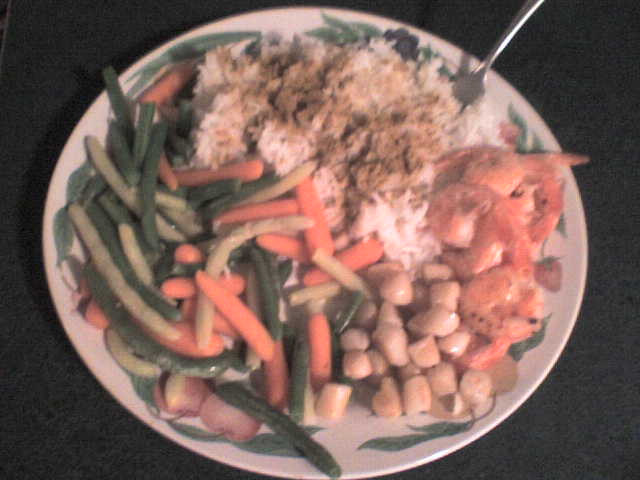 Plate of rice, shrimp, green beans, and carrots with a fork