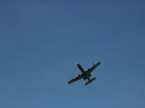 1982 Chevrolet C/K Pickup - An A-10 Thunderbolt II aircraft is seen flying against a clear blue sky.
