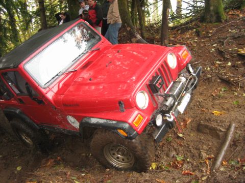 1990 Ford Bronco - This red Jeep Wrangler is stuck in the mud on a wooded trail.