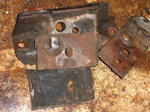 1989 Ford Bronco - Several heavily rusted metal brackets and degraded rubber mounts are shown in this close-up view.
