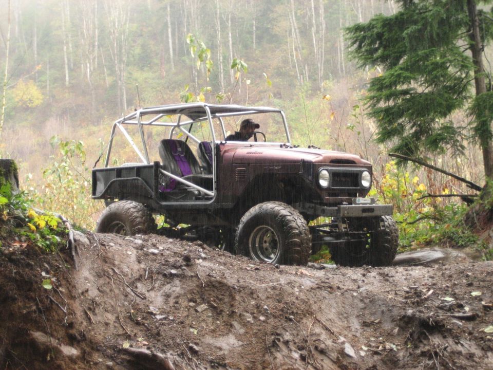 Custom off-road vehicle with roll cage on muddy terrain