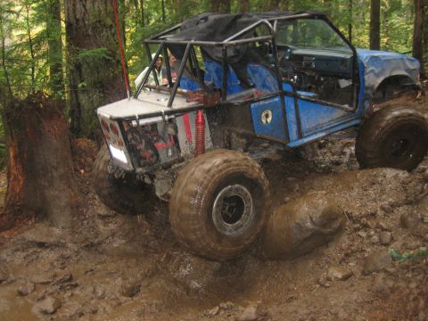 1990 Ford Bronco - This heavily modified off-road vehicle is shown on a challenging muddy course.