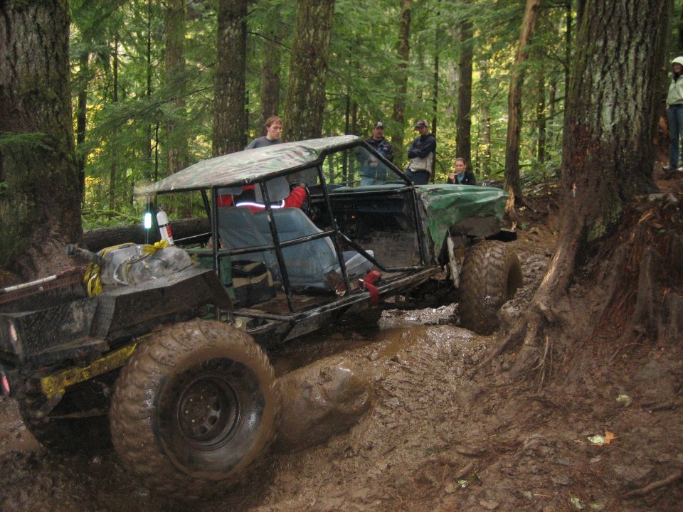 Modified off-road vehicle with large tires stuck in mud
