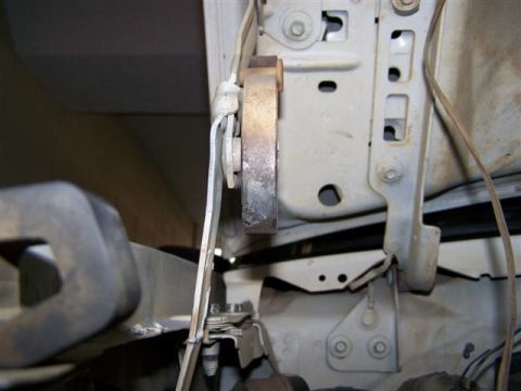 1995 Ford Bronco - Detail of a vehicle's hood latch mechanism, showing wear and exposed wiring.
