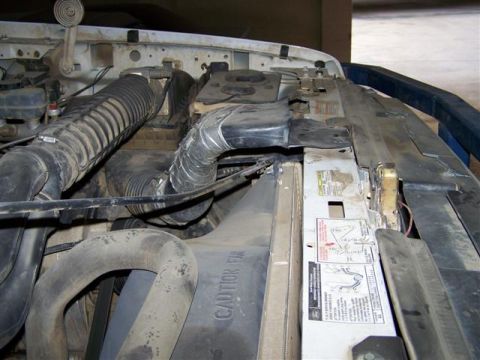 1995 Ford Bronco - Close-up view of the engine bay in a 1995 Ford Bronco, showing various hoses and the radiator.