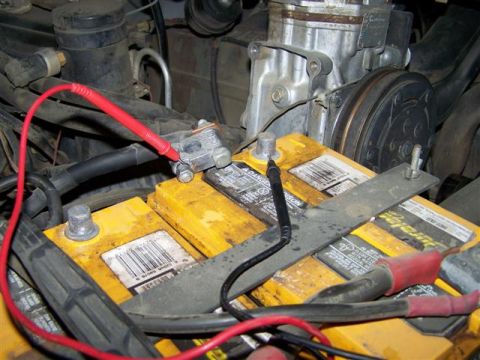 1995 Ford Bronco - Testing the voltage of dual Optima batteries in a vehicle's engine compartment.