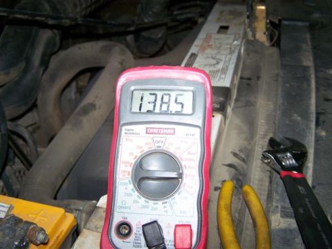 1995 Ford Bronco - A multimeter displays 138.5 volts in an engine bay, with tools nearby.