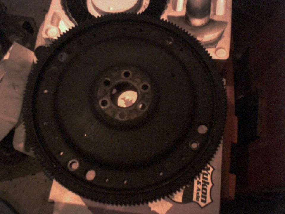 Close-up of a car flywheel with gear teeth around the edge