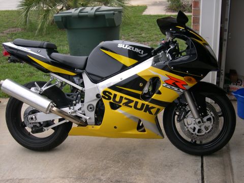 1997 Ford Probe - A yellow and black Suzuki GSX sportbike is parked in front of a garage.