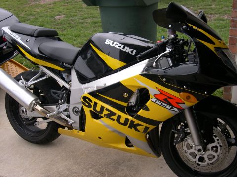 1997 Ford Probe - A Suzuki sportbike with prominent "SUZUKI" and "GSX-R" graphics is shown from the front three-quarter view.