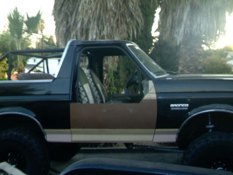 1989 Ford Bronco - Side view of a 1989 Ford Bronco, showing its interior and roll cage.