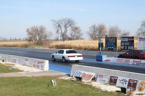 1997 Mercury Grand Marquis - White 1997 Mercury Grand Marquis at a drag strip with a red car in the background.