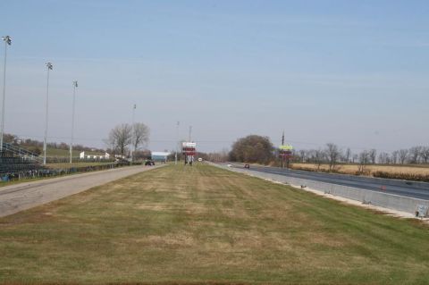 1997 Mercury Grand Marquis - A drag strip scene with cars visible on the track under a clear sky.