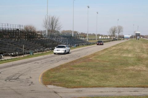 1997 Mercury Grand Marquis - A white 1997 Mercury Grand Marquis is seen on a track with another vehicle in the distance.
