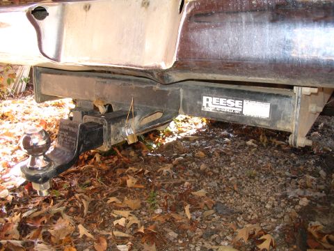 1984 Ford Bronco - Close-up of a vehicle's rear bumper and a Reese trailer hitch assembly, secured with a padlock.