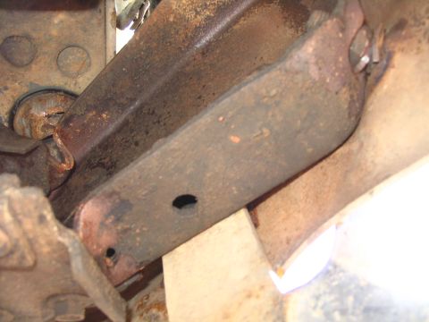 1984 Ford Bronco - Close-up view of heavily rusted metal frame components, suggesting significant wear or damage.