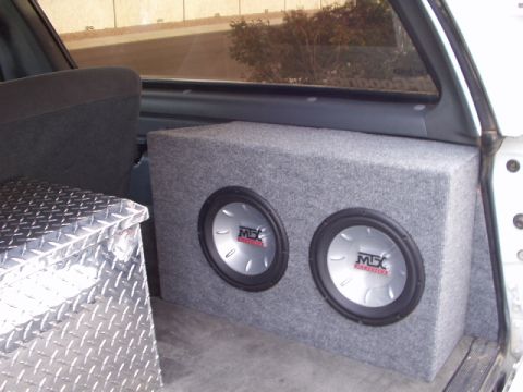 1993 Ford Bronco - Dual subwoofers are installed in the cargo area of a vehicle, alongside a diamond plate toolbox.
