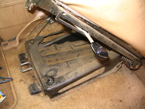 1984 Ford Bronco - Close-up of a vehicle's interior seat base and mechanism.