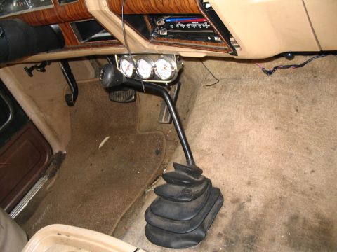 1984 Ford Bronco - Aftermarket gauges and shifter installed in a vehicle's interior.