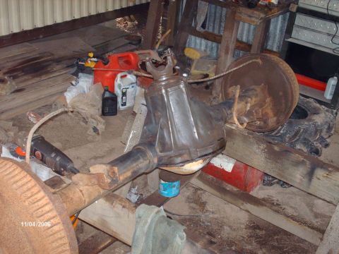 1990 Ford F-150 - A close-up of a vehicle's differential and axle assembly, with a brake drum and driveshaft yoke visible.