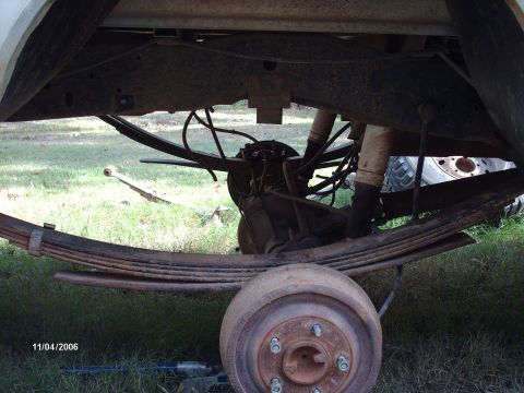 1990 Ford F-150 - The photo shows the rear suspension and axle assembly of a vehicle, with a spare leaf spring on the ground.