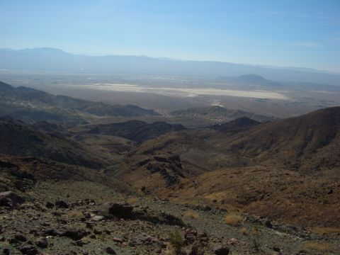 1985 Ford Bronco - A vast desert landscape unfolds with rolling hills, mountains, and a distant valley under a clear blue sky.