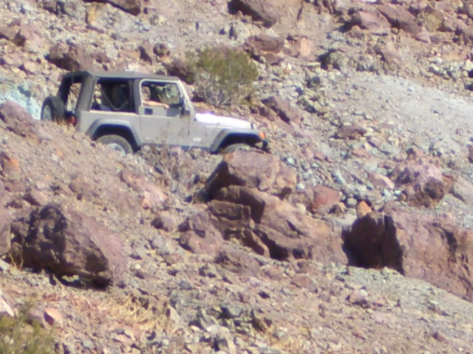 Tan Jeep Wrangler TJ on rocky hillside