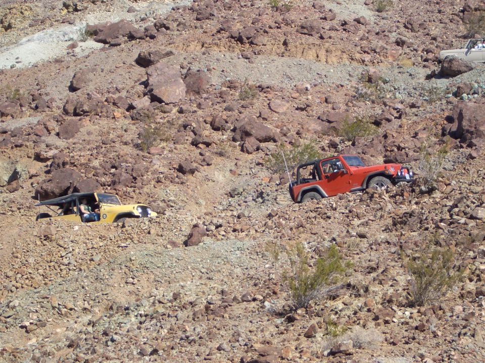Orange Jeep and yellow Jeep navigating a rocky, off-road terrain