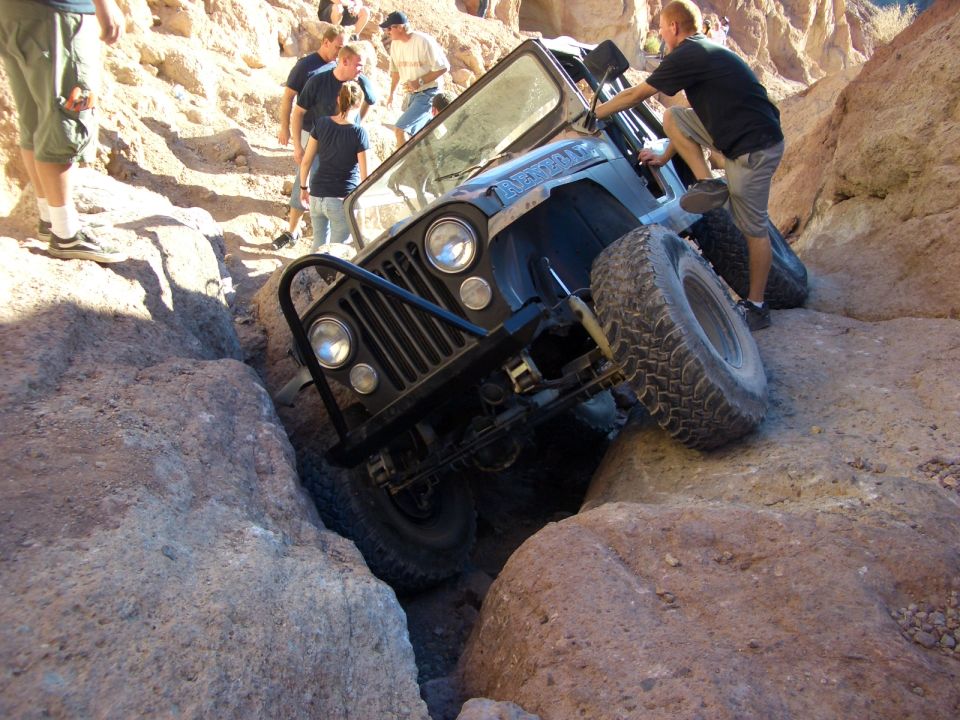 Black Jeep CJ-7 navigating a narrow rocky canyon