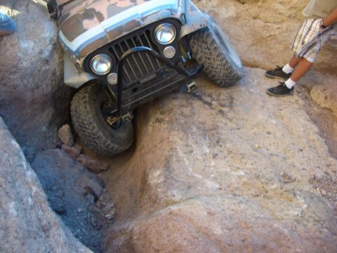 1985 Ford Bronco - Jeep CJ-7 front end is stuck between rocks on an off-road trail.