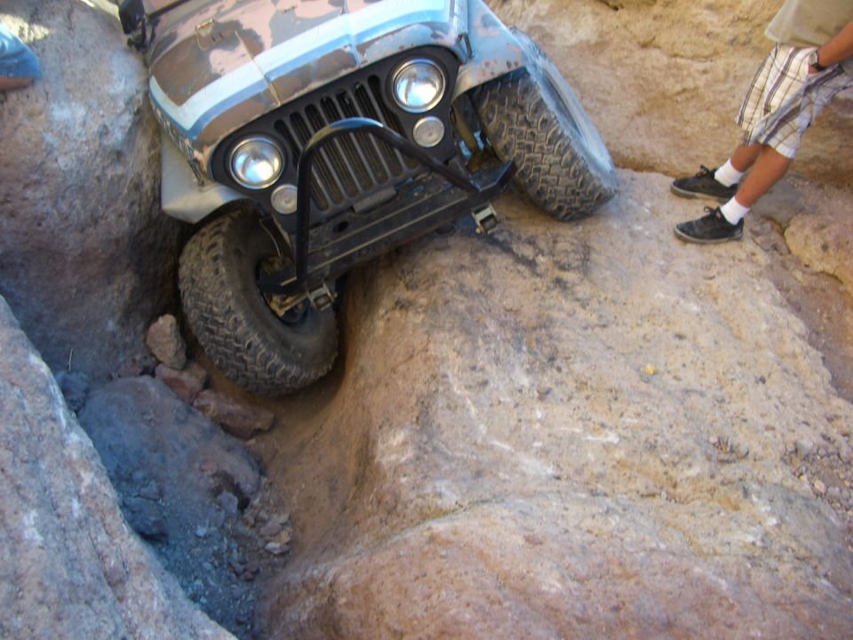 Jeep CJ-7 front end stuck between rocks on off-road trail