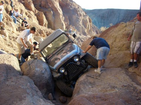 1985 Ford Bronco - Off-roaders assist a Jeep Wrangler that has become wedged between large rocks in a canyon.
