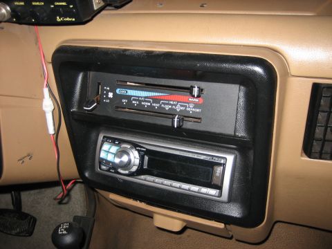 1990 Ford Bronco - The dashboard of a car shows climate controls, an aftermarket stereo, and a gear shift lever.